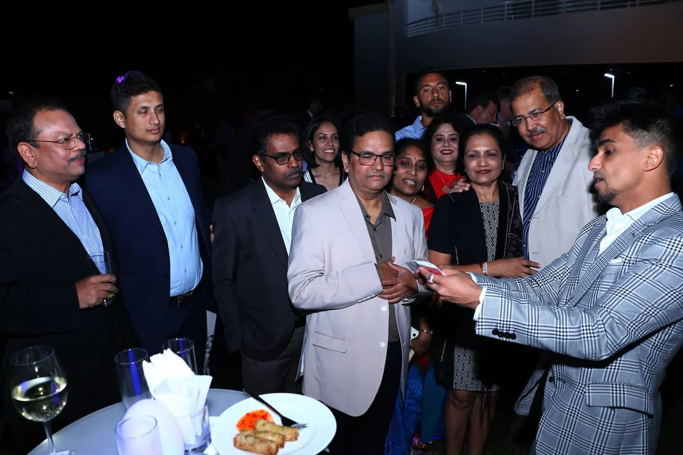 Nabeel performs card magic for a group of guests at a reception.