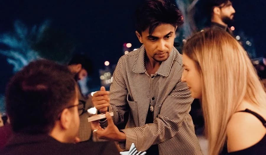 Nabeel leans towards guests during a close-up performance.